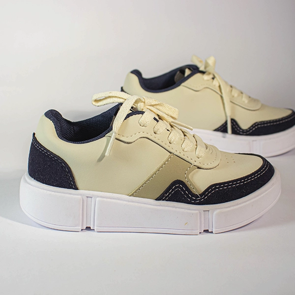 Par de tênis plataforma creme e azul marinho com cadarços claros em fundo branco. Calçado casual moderno.