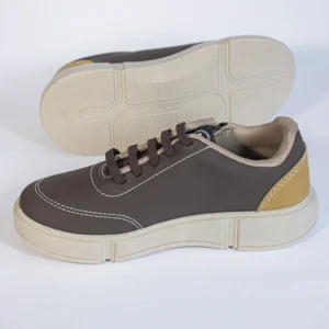 Tênis casual masculino marrom com cadarços e solado bege, detalhe em costura branca, ideal para conforto e estilo.