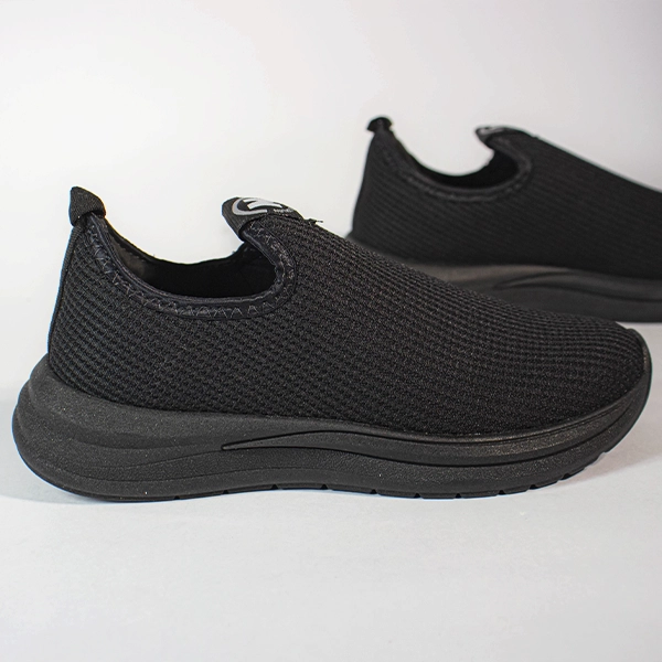 Tênis slip-on preto de malha respirável, com sola grossa e design casual para conforto diário.