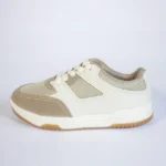 Tênis casual bege e creme com detalhes em tela, sola branca e borracha natural. Calçado unissex moderno.